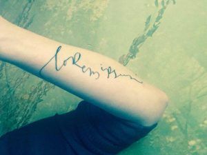Brazo tatuado con Lorem ipsum